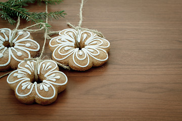 Image showing Gingerbread cookies hanging over wooden background 
