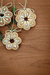 Image showing Gingerbread cookies hanging over wooden background 