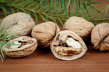 Image showing walnuts and a cracked walnut on wooden background