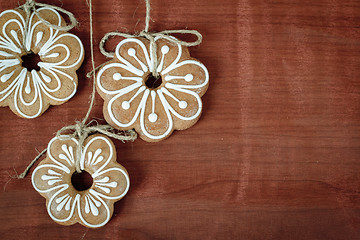 Image showing Gingerbread cookies hanging over wooden background 
