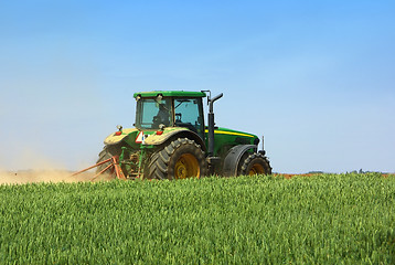 Image showing Green tractor working in the field. 
