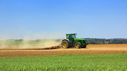 Image showing Green tractor working in the field. 