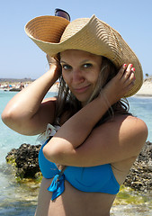 Image showing Young woman in straw hat on the beach