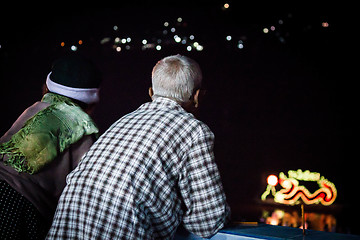 Image showing Asian senior couple view river decorated light