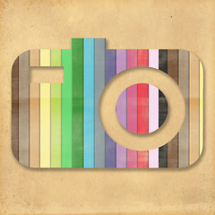 Image showing retro camera icon with rainbow colors on cork board background 