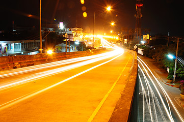 Image showing highway bridge at night with traces of light traffic 