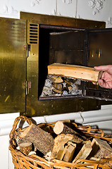 Image showing Puting firewood into fireplace