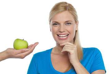 Image showing Attractive woman is being offered a green apple