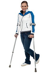 Image showing Woman walking with the support of crutches