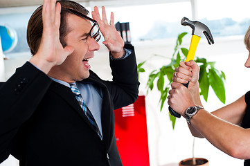 Image showing Woman threatening her boss, holding hammer.