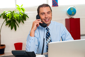 Image showing Smiling manager in middle of business interactions