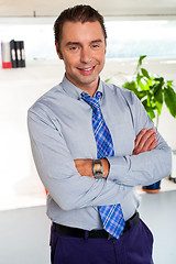 Image showing Young manager in formals standing with arms crossed