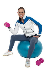 Image showing Fit woman doing biceps exercise with pink dumbbells