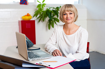 Image showing Casual portrait of a woman seated at her work place