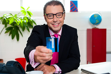 Image showing Smiling business executive displaying credit card