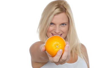 Image showing Gorgeous woman with an orange in her outstretch arm