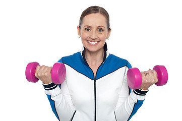 Image showing Happy woman carrying dumbbells in both hands