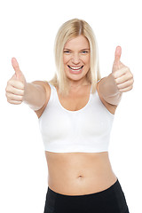 Image showing Fit woman in sports bra gesturing double thumbs up