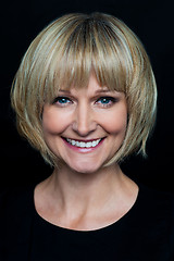 Image showing Cheerful blonde woman on black background