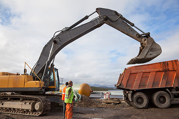 Image showing Excavator bucket on a dump truck lifted