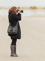 Image showing Lonely photographer walking on a beach