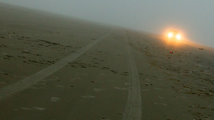 Image showing Car headlights of a car on the beach