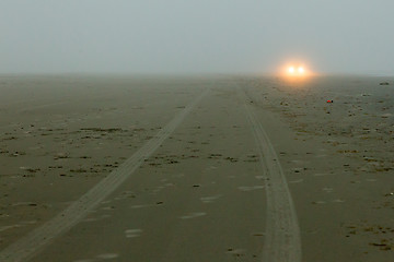 Image showing Car headlights of a car on the beach