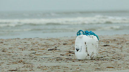 Image showing Container with acid on a beach