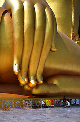 Image showing Hand of Biggest Golden Buddha in thai temple of in Thailand and three monks 