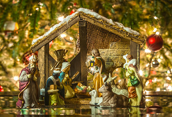 Image showing Old handmade nativity scene in front of a christmas tree