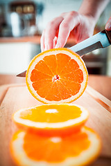 Image showing Woman's hands cutting orange