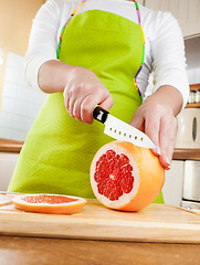 Image showing Woman's hands cutting grapefruit