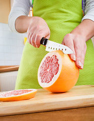 Image showing Woman's hands cutting grapefruit