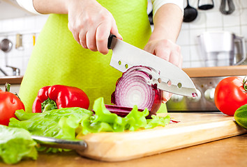 Image showing Woman's hands cutting bulb onion