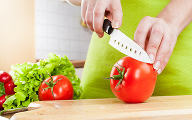 Image showing Woman's hands cutting tomato