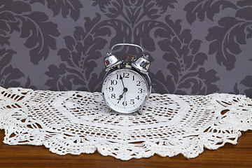 Image showing Antique alarm clock on table cloth 