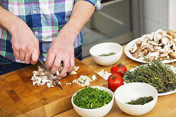 Image showing Man Chopping Mushrooms With Vegetables On Counter