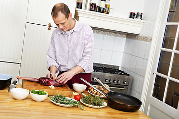Image showing Man Preparing Meat In Kitchen