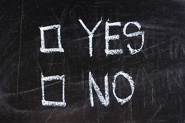 Image showing yes and no check boxes sketched with white chalk on blackboard with eraser smudges 