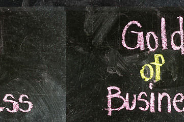 Image showing GOLD OF BUSINESS handwritten with white chalk on a blackboard