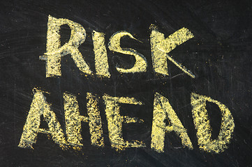 Image showing risks ahead sign on black board