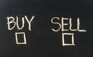 Image showing Buy or sell check boxes written on a blackboard