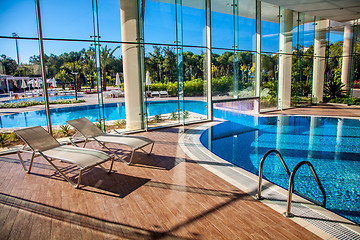 Image showing Sunbeds in the indoor swimming pool