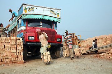 Image showing Brick field workers carrying complete finish brick from the kiln