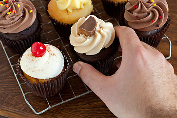 Image showing Person Choosing a Cupcake