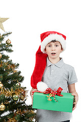 Image showing happy boy in santa hat surprised by christmas present