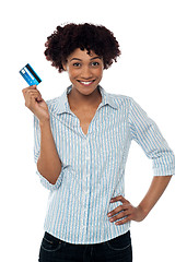 Image showing Cheerful lady in casuals holding up cash card