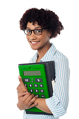 Image showing Young businesswoman with calculator and file