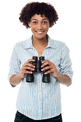 Image showing Smiling afro american woman holding binocular