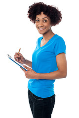 Image showing Young lady documenting instructions on clipboard